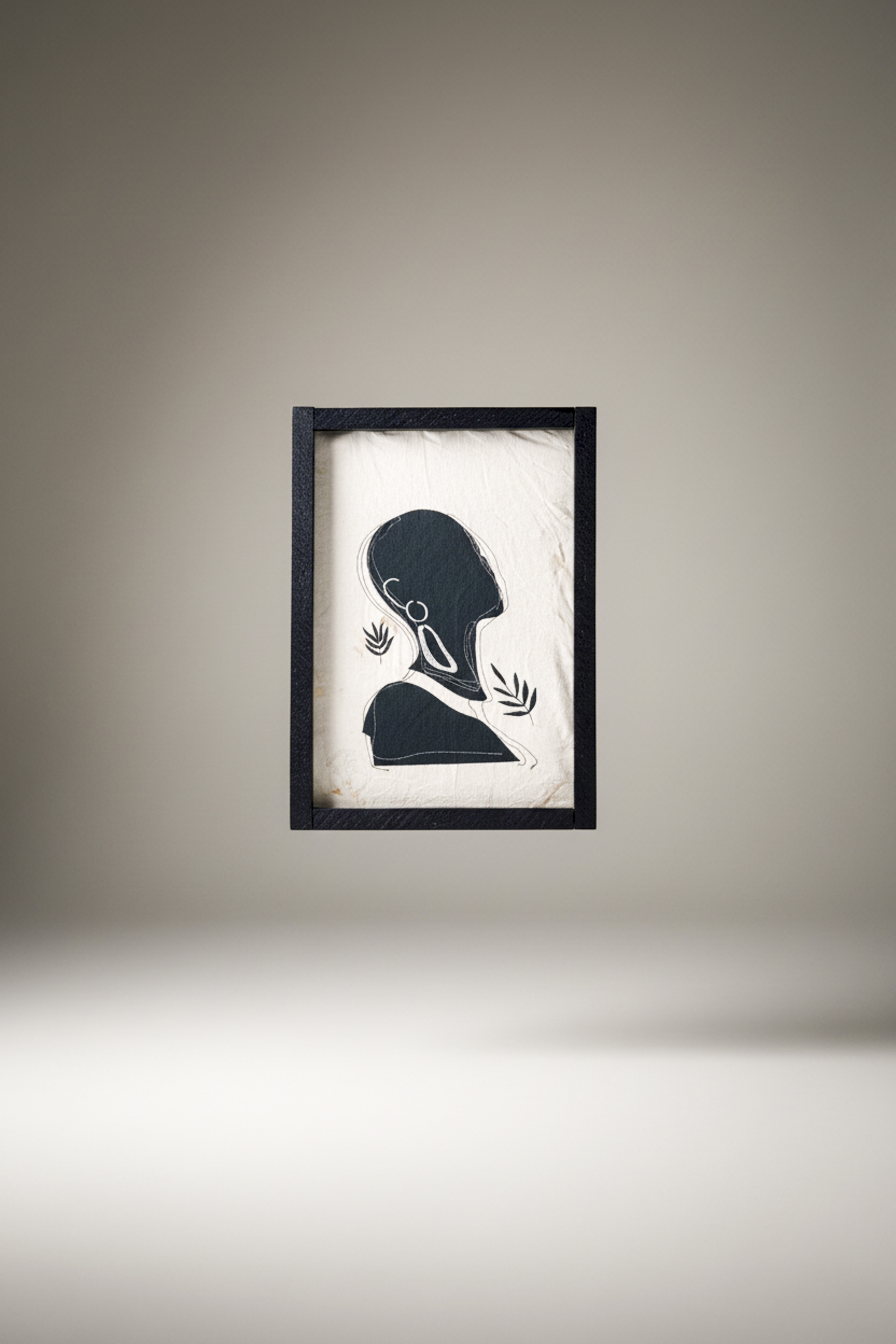 Minimalist black silhouette art print features a textured beige background framed in dark wood.  